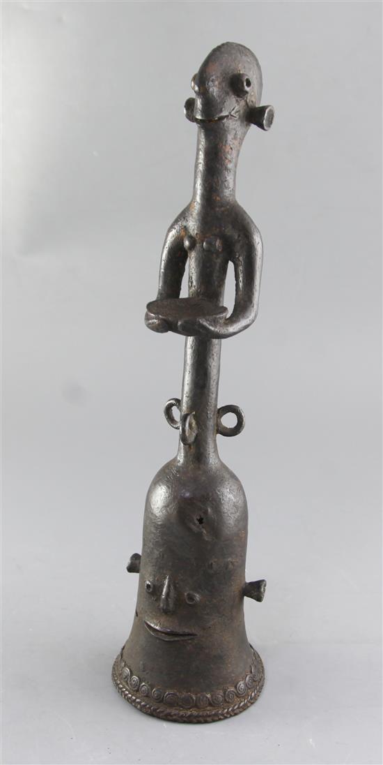 A Bankoni bronze ceremonial bell, modelled with a figural stem holding a bowl, height 44cm